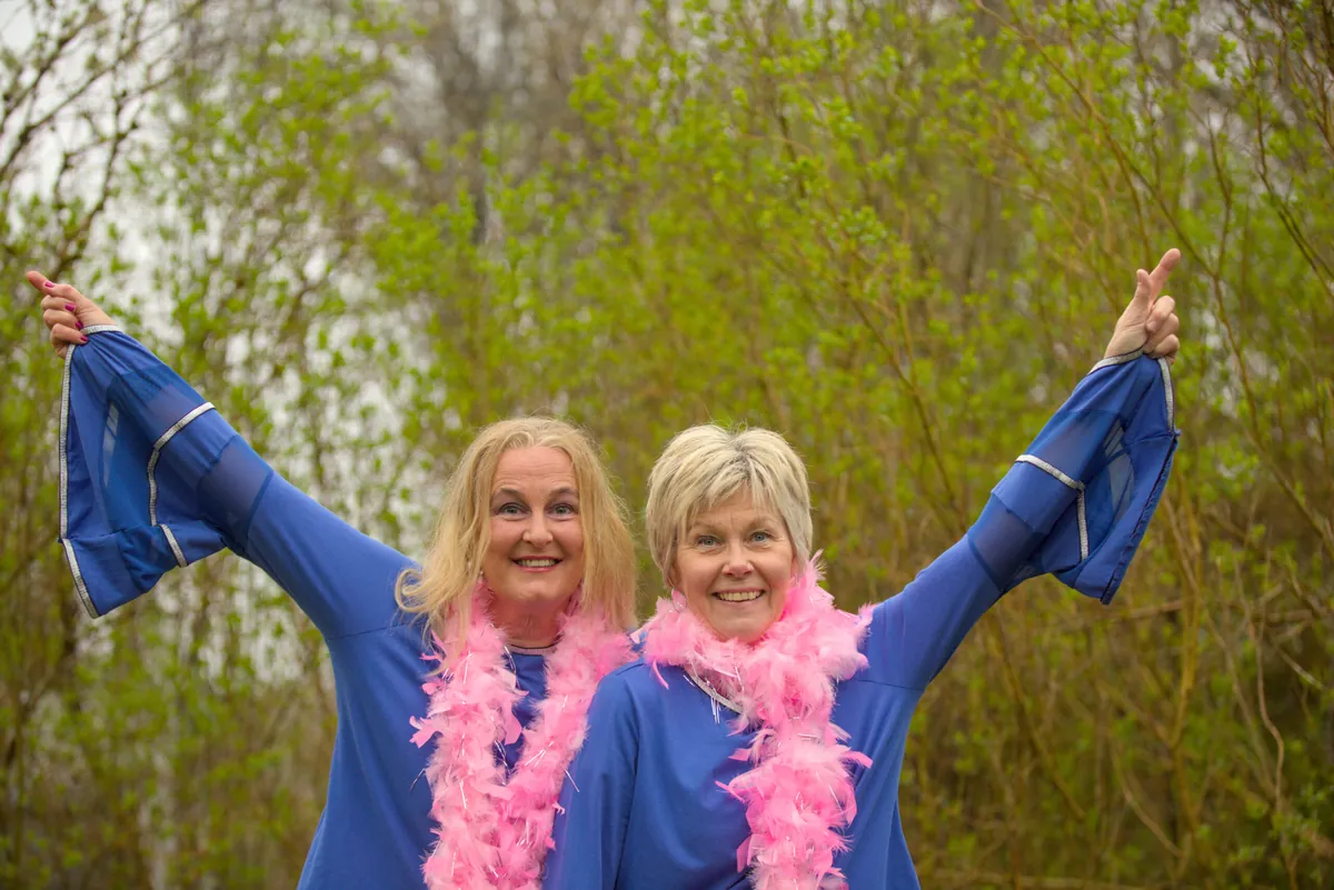 GlitterParty med rosa boa och armarna i luften